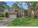 Traditional brick home with a well-manicured lawn, arched windows, and attached garage at 1400 Coachman Dr, Waxhaw, NC 28173