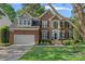 Charming brick home with a well-manicured lawn, attached garage, and mature trees in a peaceful neighborhood at 1400 Coachman Dr, Waxhaw, NC 28173