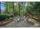 Outdoor firepit surrounded by mature trees, string lights, and chairs for relaxing evenings at 1400 Coachman Dr, Waxhaw, NC 28173