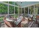 Inviting screened porch with comfortable wicker furniture, ceiling fan and wooded views at 1400 Coachman Dr, Waxhaw, NC 28173