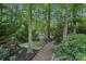 Charming shed with decorative wreaths surrounded by lush greenery and a stone pathway at 1400 Coachman Dr, Waxhaw, NC 28173