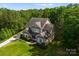 A stunning aerial view of a brick home, featuring mature trees, landscaping, and a private yard at 1410 Smoketree Ct, Waxhaw, NC 28173