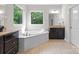 Bright bathroom features a large soaking tub with forest views and and vanities at 1410 Smoketree Ct, Waxhaw, NC 28173