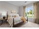 Bright bedroom featuring a large window, neutral walls, and comfortable furnishings at 1410 Smoketree Ct, Waxhaw, NC 28173