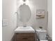 Stylish half bathroom featuring a modern vanity, oval mirror, and clean design at 1410 Smoketree Ct, Waxhaw, NC 28173