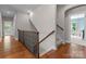 A hallway with hardwood floors features a staircase and leads to a living room with natural light at 1410 Smoketree Ct, Waxhaw, NC 28173