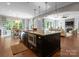 Kitchen island with granite counters offers seating and cooking space, connecting the kitchen to the dining and living areas at 1410 Smoketree Ct, Waxhaw, NC 28173