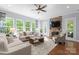 Bright living room with stone fireplace, hardwood floors, and large windows at 1410 Smoketree Ct, Waxhaw, NC 28173