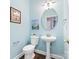 Stylish powder room with pedestal sink, round mirror, and contemporary light fixture at 14849 Middlesborough Dr, Matthews, NC 28104