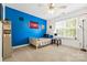 A bedroom with bright blue accent wall, ceiling fan, and large window at 14849 Middlesborough Dr, Matthews, NC 28104