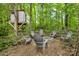 Backyard area in the woods with an inviting fire pit surrounded by Adirondack chairs at 14849 Middlesborough Dr, Matthews, NC 28104