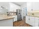Well-lit kitchen features white cabinets, stainless steel refrigerator, and stone countertops at 14849 Middlesborough Dr, Matthews, NC 28104