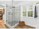 Bathroom with a frameless glass shower featuring marble walls and dark-accented fixtures at 14849 Middlesborough Dr, Matthews, NC 28104
