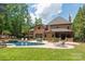 Sprawling backyard with a large pool, waterfall feature, and lush landscaping creating a private oasis at 1504 Alydar Ct, Waxhaw, NC 28173