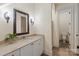 Bathroom with a large mirror, detailed sconces, and a single-sink vanity with cream-colored cabinets at 1504 Alydar Ct, Waxhaw, NC 28173
