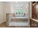 Bright bathroom with a large window above the soaking tub and custom tiled shower at 1504 Alydar Ct, Waxhaw, NC 28173