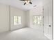 Bright bedroom featuring neutral tones, carpeted floors, two windows, and a ceiling fan at 1504 Alydar Ct, Waxhaw, NC 28173