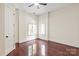Light-filled bedroom with hardwood floors, two windows, neutral tones, and a ceiling fan at 1504 Alydar Ct, Waxhaw, NC 28173