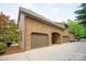 Stucco garage and porte-cochere with handsome wood doors; ample parking on concrete pad at 1504 Alydar Ct, Waxhaw, NC 28173