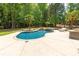 Sparkling pool with a waterfall feature, lush landscaping, lounge chairs, and outdoor kitchen at 1504 Alydar Ct, Waxhaw, NC 28173