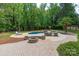 Inviting pool area featuring lush landscaping, an outdoor kitchen, firepit, and lounge chairs at 1504 Alydar Ct, Waxhaw, NC 28173
