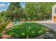 Backyard featuring a small lawn and patio with Adirondack chairs surrounded by landscape at 1822 Hall Ave, Charlotte, NC 28205