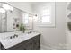Bathroom featuring a double vanity with marble countertop, a large framed mirror, and sconce lighting at 1822 Hall Ave, Charlotte, NC 28205