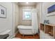 Bright bathroom featuring a clawfoot tub, wood floors, and a stained glass window at 1822 Hall Ave, Charlotte, NC 28205