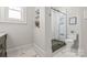 Bright bathroom with black-framed glass shower, subway tile, dark flooring accents, and decorative floor tiles at 1822 Hall Ave, Charlotte, NC 28205