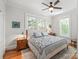 Comfortable bedroom with hardwood floors, ceiling fan, and natural light from large windows with backyard views at 1822 Hall Ave, Charlotte, NC 28205