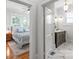 View of a bedroom with hardwood floors and a view of a gray-toned bathroom with decorative floor tiles at 1822 Hall Ave, Charlotte, NC 28205