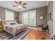 Bedroom features hardwood floors, a ceiling fan, and natural light from large windows at 1822 Hall Ave, Charlotte, NC 28205