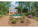 Stunning front exterior view showcasing a lush landscape and two teal Adirondack chairs in front of a two-car garage at 1822 Hall Ave, Charlotte, NC 28205