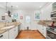 Well-lit kitchen featuring white cabinetry, granite countertops, a stainless steel stove, and hardwood floors at 1822 Hall Ave, Charlotte, NC 28205