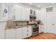Close-up of a bright kitchen featuring white cabinets, granite countertops, and stainless steel appliances at 1822 Hall Ave, Charlotte, NC 28205