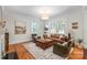 Bright living room with hardwood floors, neutral walls, a tan sofa, and natural light from surrounding windows at 1822 Hall Ave, Charlotte, NC 28205