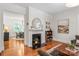 Cozy living room with a decorative fireplace, hardwood floors, and open access to the dining room at 1822 Hall Ave, Charlotte, NC 28205