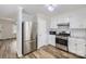 Well-equipped kitchen featuring stainless steel appliances, white cabinets, and hardwood floors at 201-A Ewing Dr, Belmont, NC 28012