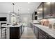 A modern kitchen features an island, pendant lighting, stainless appliances, and a gas cooktop at 2010 Puddle Pond Rd, Indian Trail, NC 28079