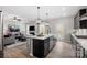 A modern open-concept kitchen with island, pendant lighting, gas cooktop, and view to the living room at 2010 Puddle Pond Rd, Indian Trail, NC 28079