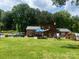 Expansive backyard with lush green lawn, patio furniture, and mature trees providing ample shade at 204 Aspen Dr, Gastonia, NC 28052