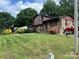 Brick home showing manicured lawn, lush landscaping, fountain, and neighboring house at 204 Aspen Dr, Gastonia, NC 28052