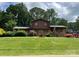 Charming two-story home with brick facade, red shutters, well-manicured lawn and landscaped yard at 204 Aspen Dr, Gastonia, NC 28052