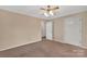 A beige carpeted bedroom featuring a ceiling fan and doors to additional rooms at 212 Pointe Cir, Rock Hill, SC 29732