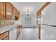 Bright kitchen with white tile floors, appliances, and wooden cabinets for ample storage at 212 Pointe Cir, Rock Hill, SC 29732