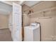 Convenient laundry room with white washer, storage shelves, and rod for hanging clothes at 212 Pointe Cir, Rock Hill, SC 29732