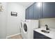 Convenient laundry room featuring a washer, dryer, sink, and stylish blue storage cabinets at 21203 Harken Dr, Cornelius, NC 28031