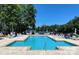 Beautiful community pool with lounging chairs and umbrellas overlooking the lake at 21203 Harken Dr, Cornelius, NC 28031