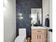 Chic powder room with herringbone accent wall, modern vanity, and stylish fixtures at 21203 Harken Dr, Cornelius, NC 28031