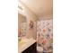 Bright bathroom with a colorful floral shower curtain, vanity, and well-lit mirror at 217 Hydrangea Dr, Clover, SC 29710